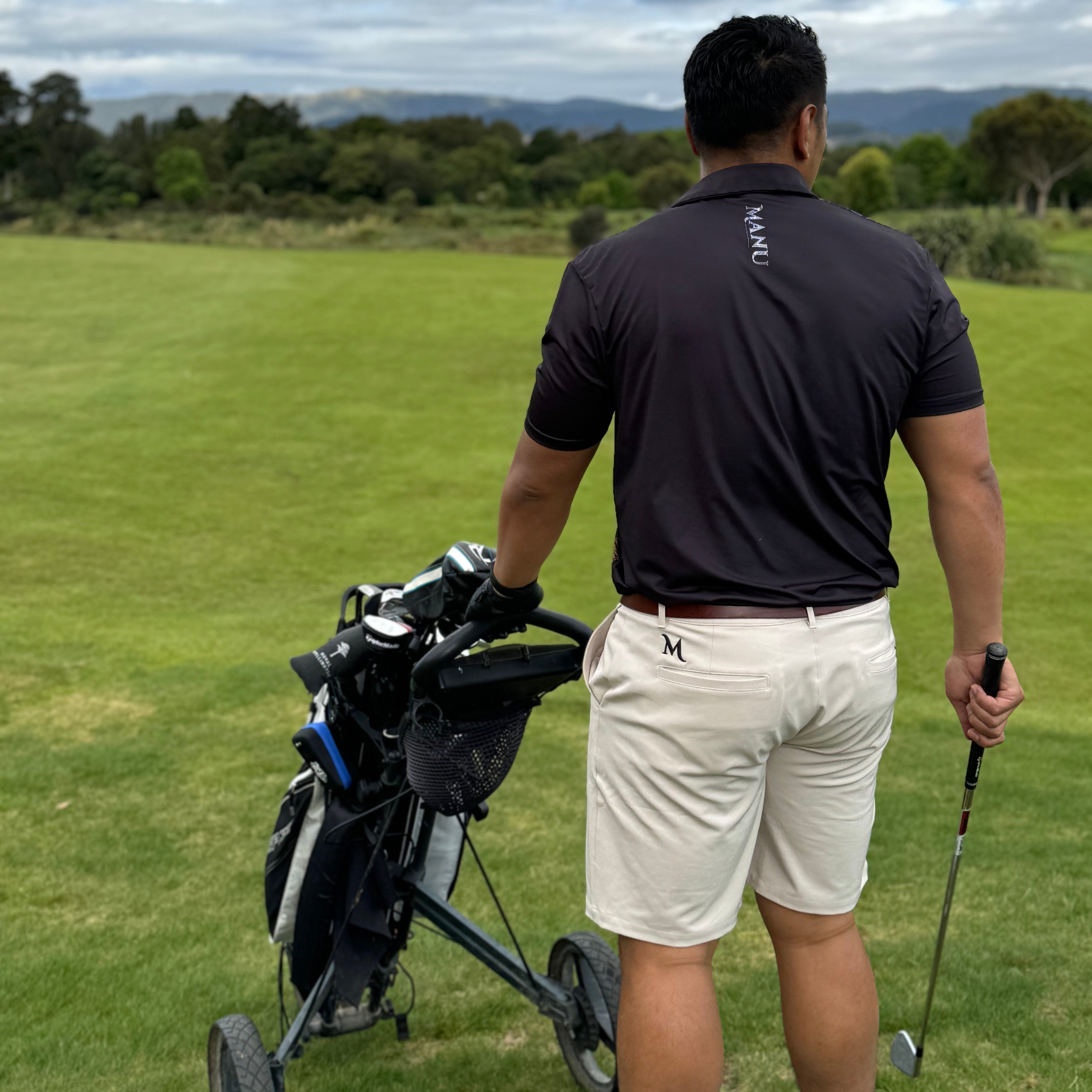 Man in a Heritage Golf Polo walking on the golf course with a golf bag.