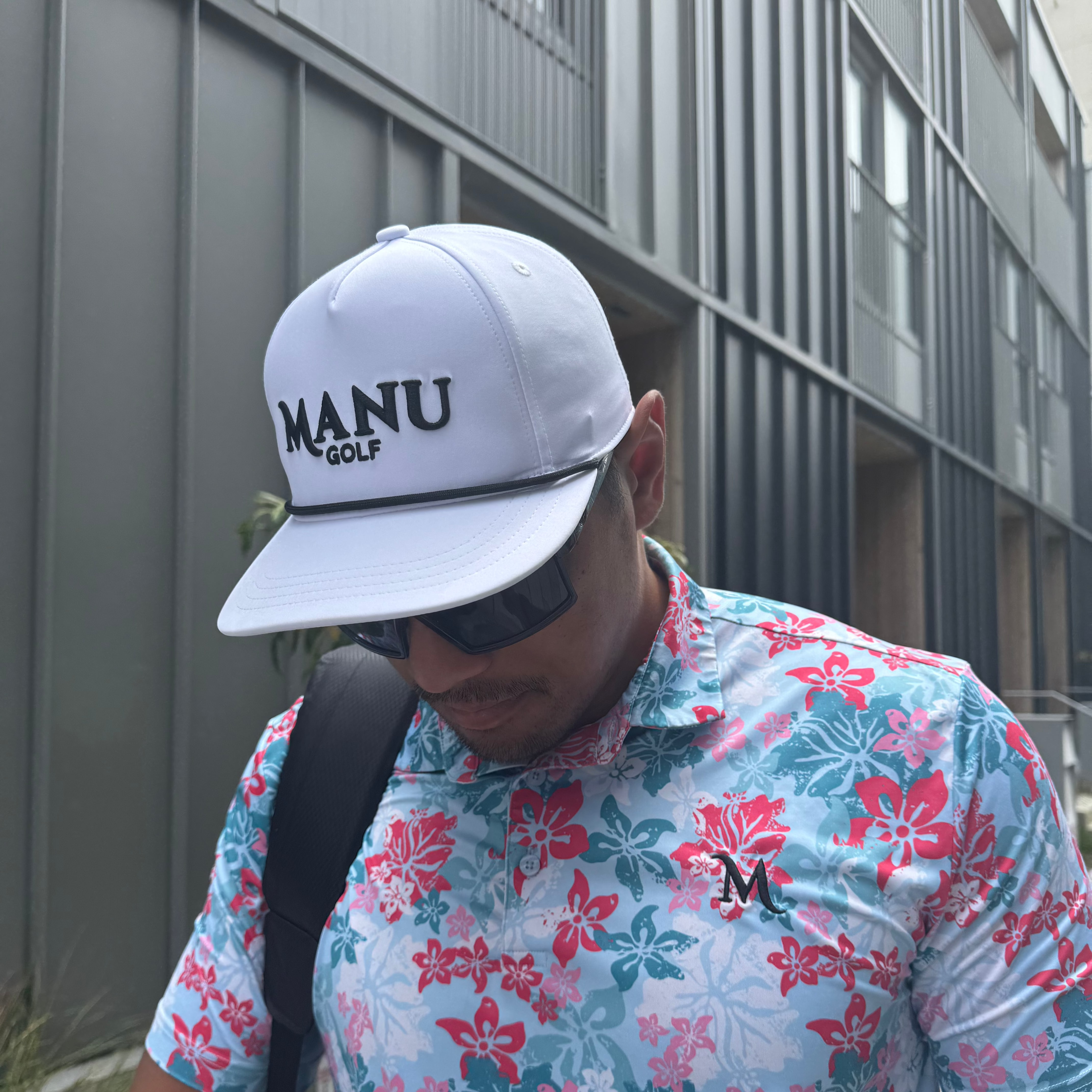 Model in White Manu Golf Hat – Breathable, moisture-wicking performance cap with adjustable fit and embroidered logo.