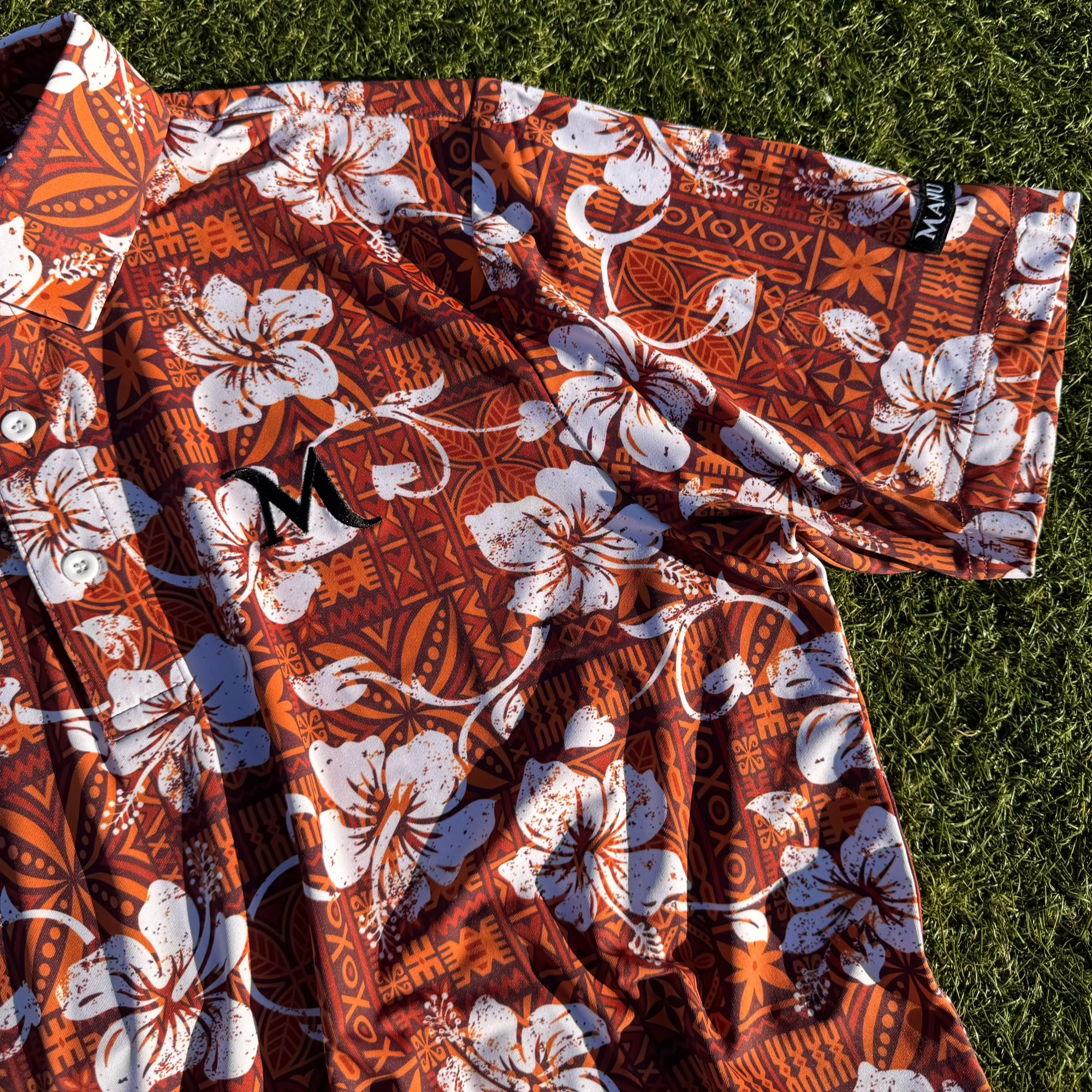 Close up of the Island Roots Golf Polos. Showing the arm and main Manu logo.