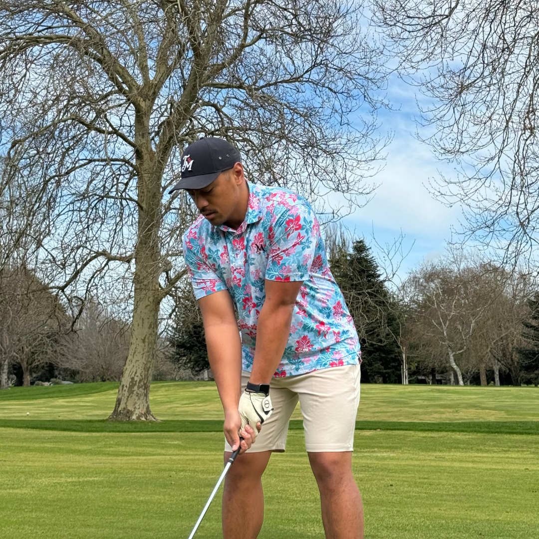 Model wearing the Island Bloom Polo shirt on the golf course, with a Polynesian-inspired design. Proudly designed in New Zealand.